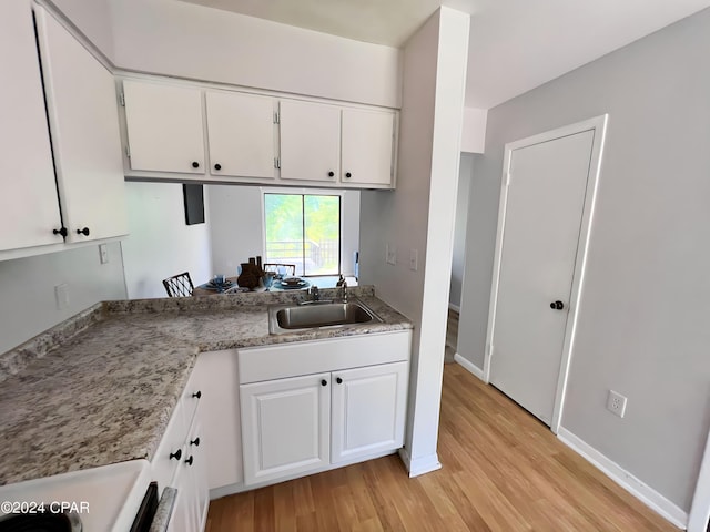 1730 Mallard Dr Apt F, Panama City, FL 32404 - kitchen featuring light countertops, a sink, light wood finished floors, white cabinetry, and stove