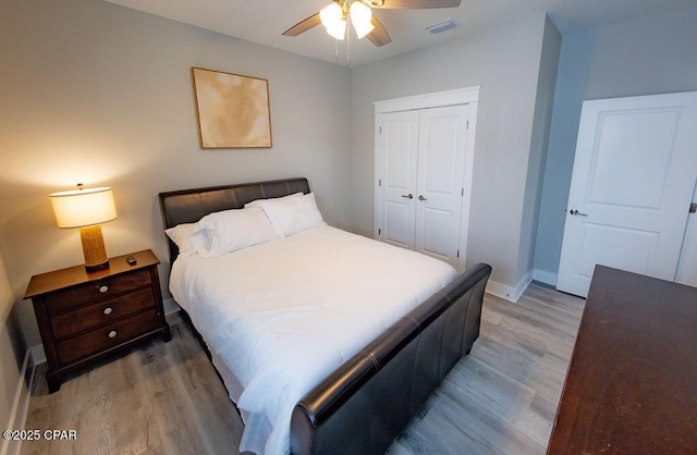 bedroom with ceiling fan, wood-type flooring, and a closet