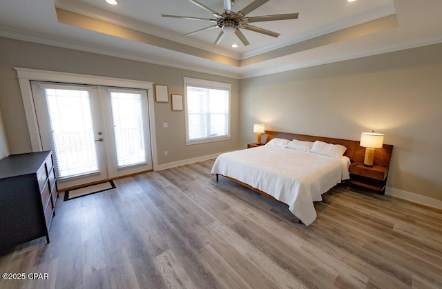 bedroom featuring hardwood / wood-style floors, ceiling fan, and a tray ceiling