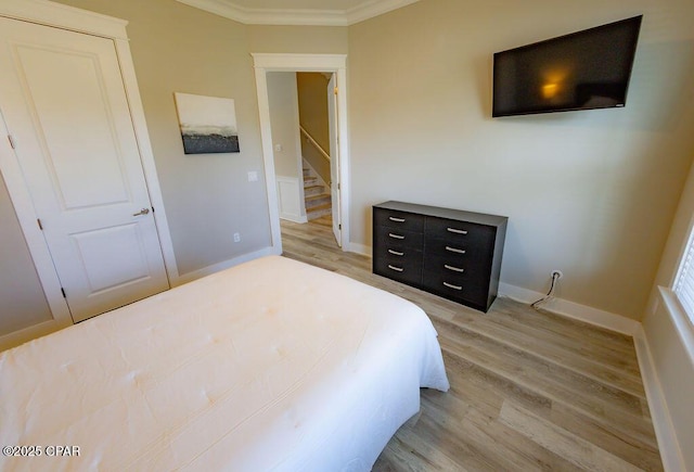 bedroom featuring crown molding and light hardwood / wood-style floors