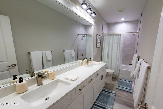 full bathroom featuring hardwood / wood-style floors, vanity, toilet, and shower / bathtub combination with curtain