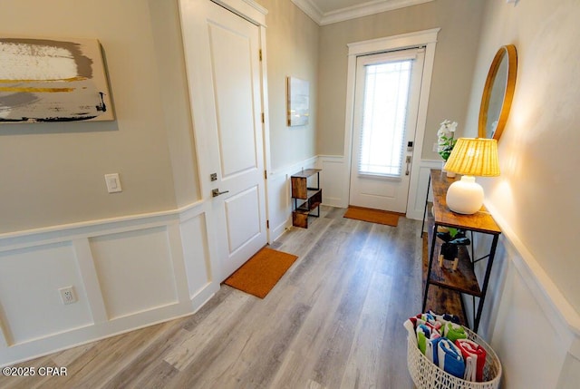 doorway with light wood-type flooring and ornamental molding