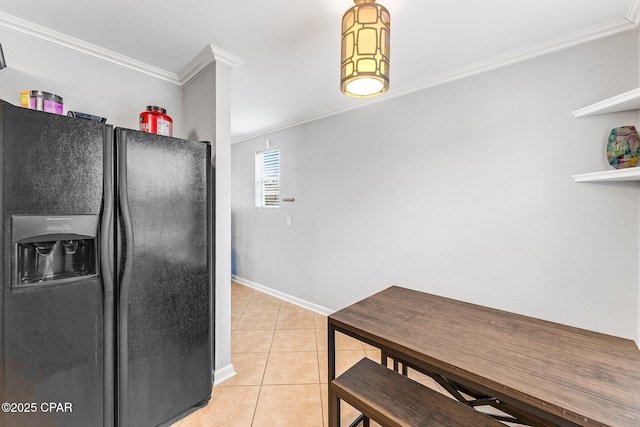 kitchen with light tile patterned floors, ornamental molding, baseboards, and black refrigerator with ice dispenser