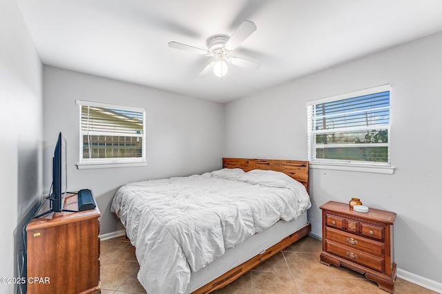 bedroom featuring light tile patterned floors, baseboards, and ceiling fan