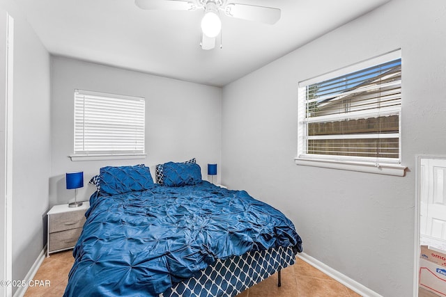 tiled bedroom with baseboards and ceiling fan