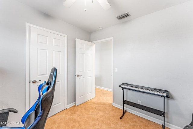 office with light tile patterned floors, visible vents, ceiling fan, and baseboards