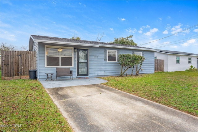 ranch-style house featuring a front yard and fence