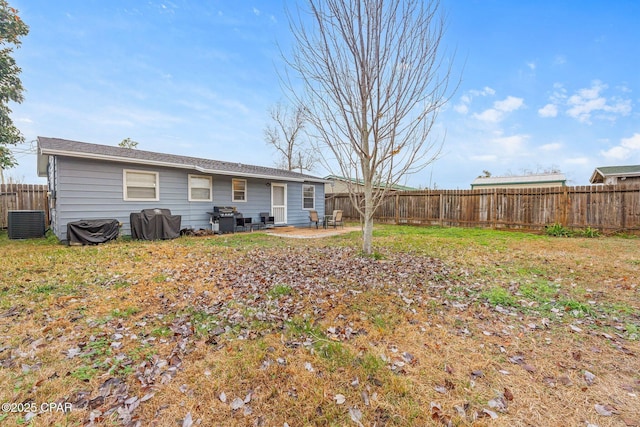 back of house with central AC unit, a fenced backyard, and a patio area