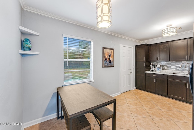 kitchen with dark brown cabinetry, light tile patterned floors, tasteful backsplash, and a sink