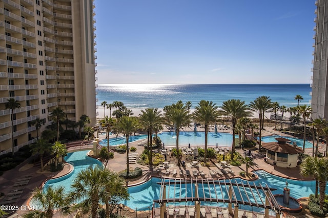 view of swimming pool with a water view and a beach view