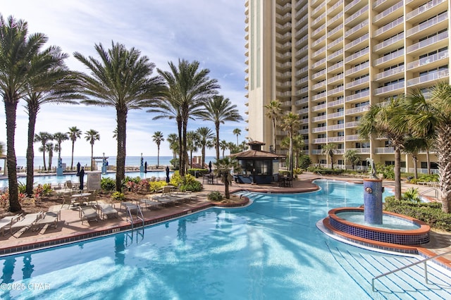 view of swimming pool with a patio area, a gazebo, a hot tub, and a water view