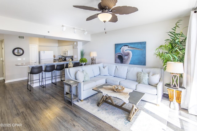 living room with ceiling fan, dark wood-type flooring, and rail lighting