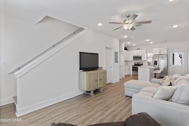 living room with crown molding, light hardwood / wood-style flooring, ceiling fan, and electric panel