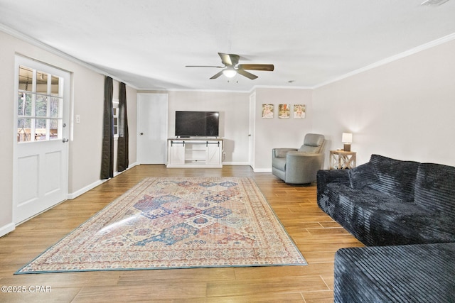 living room with hardwood / wood-style flooring, crown molding, and ceiling fan