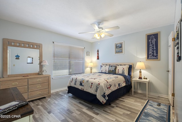 bedroom featuring light wood-style flooring, baseboards, and ceiling fan