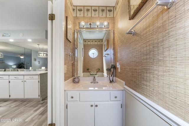 bathroom with ceiling fan, wood finished floors, and vanity