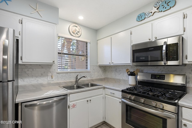 kitchen featuring a sink, stainless steel appliances, light countertops, white cabinetry, and tasteful backsplash