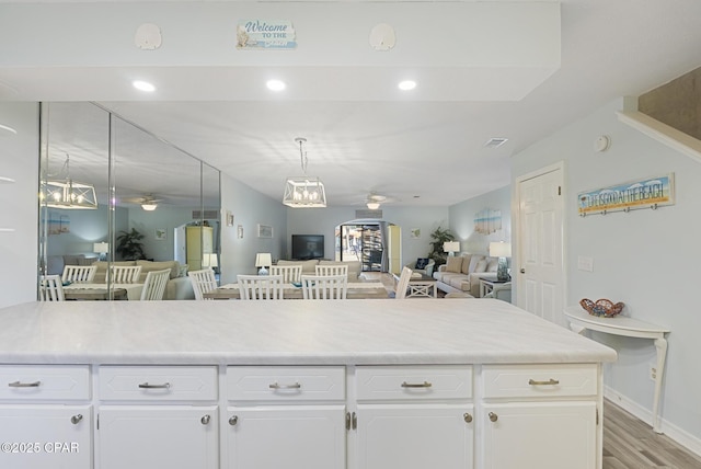 kitchen with light countertops, open floor plan, and ceiling fan