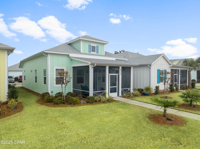 rear view of property featuring a sunroom and a yard