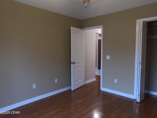 unfurnished bedroom featuring dark hardwood / wood-style flooring and a closet