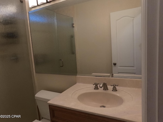 bathroom with sink, a shower with shower door, and toilet