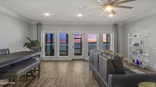 living room featuring a water view, ceiling fan, ornamental molding, and hardwood / wood-style flooring