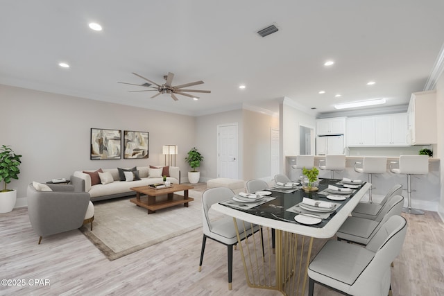 dining area featuring crown molding, light hardwood / wood-style flooring, and ceiling fan