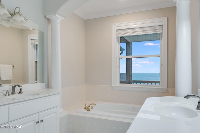 bathroom featuring tiled bath, vanity, decorative columns, and a water view