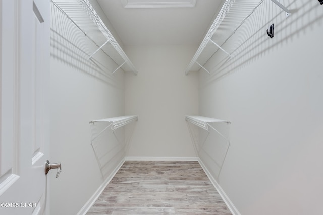 spacious closet with light hardwood / wood-style floors