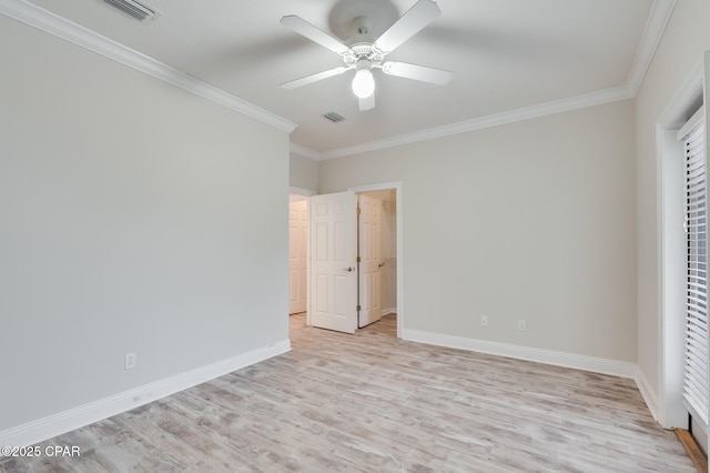 unfurnished bedroom featuring a walk in closet, light hardwood / wood-style flooring, ornamental molding, and ceiling fan