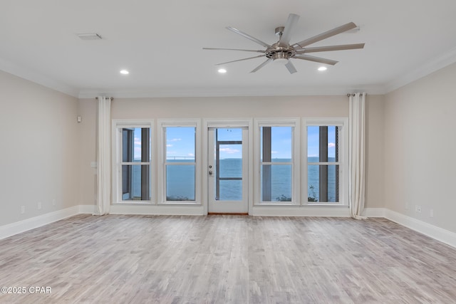 empty room with a water view, ceiling fan, ornamental molding, and light hardwood / wood-style floors