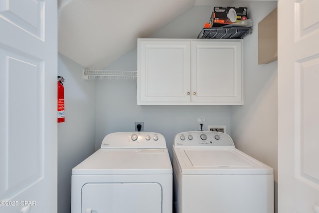 clothes washing area featuring cabinets and washer and clothes dryer