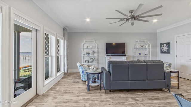 living room with crown molding, ceiling fan, and light hardwood / wood-style floors