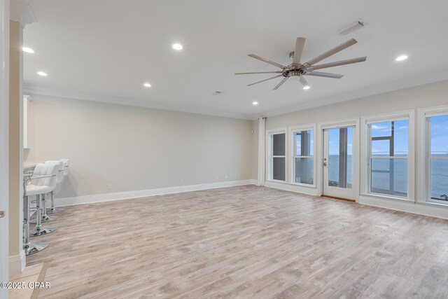 interior space featuring ceiling fan, crown molding, a water view, and light wood-type flooring