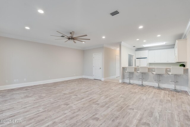 unfurnished living room with ceiling fan, light wood-type flooring, and crown molding