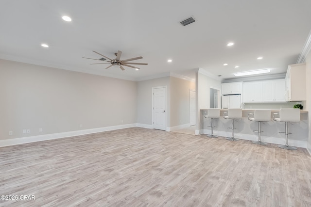 unfurnished living room featuring ceiling fan, ornamental molding, and light hardwood / wood-style flooring