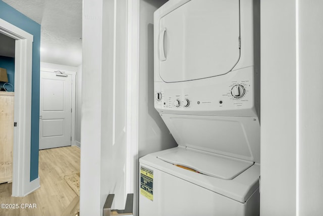 15928 Front Beach Rd Unit 3-1610, Panama City Beach, FL 32413 - laundry room with stacked washing machine and dryer, light wood-style flooring, and baseboards