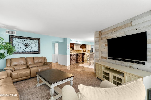 living room featuring wooden walls and light tile patterned floors