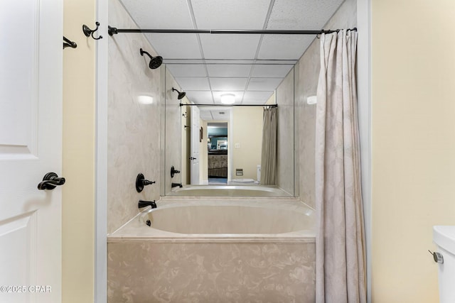 bathroom featuring shower / bath combo and a drop ceiling