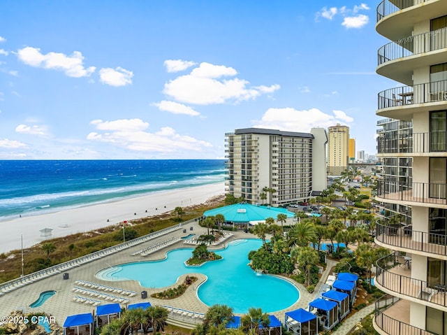 view of swimming pool featuring a beach view, a patio, and a water view