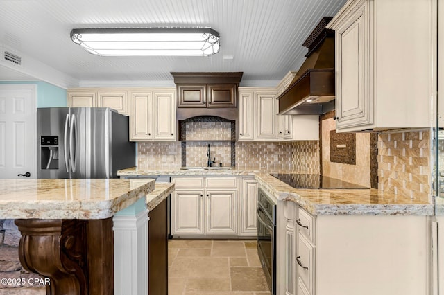 kitchen featuring custom exhaust hood, appliances with stainless steel finishes, a kitchen bar, sink, and cream cabinets