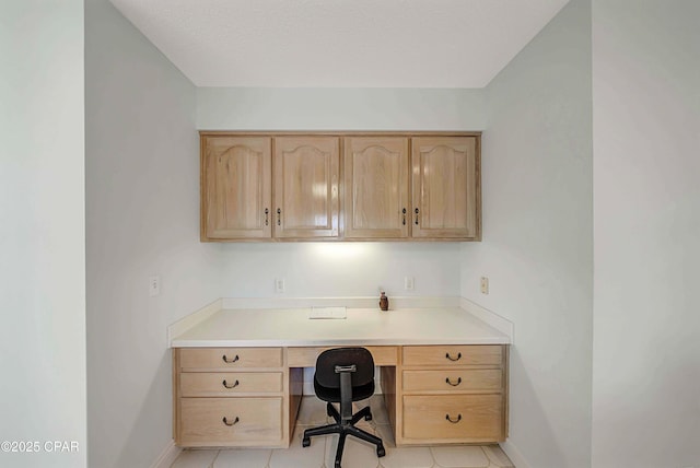 office with built in desk and light tile patterned floors