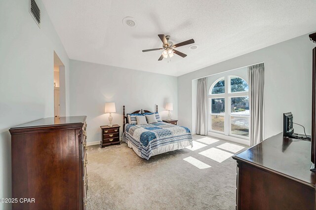 carpeted bedroom with a textured ceiling and ceiling fan