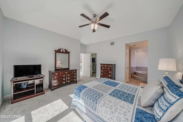 carpeted bedroom with ensuite bathroom and ceiling fan