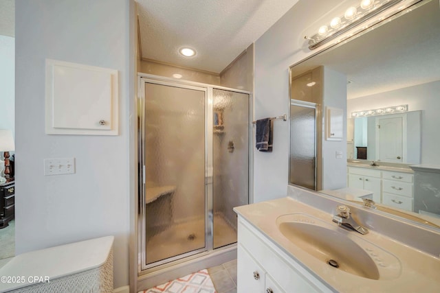 bathroom featuring vanity, tile patterned floors, a textured ceiling, and walk in shower