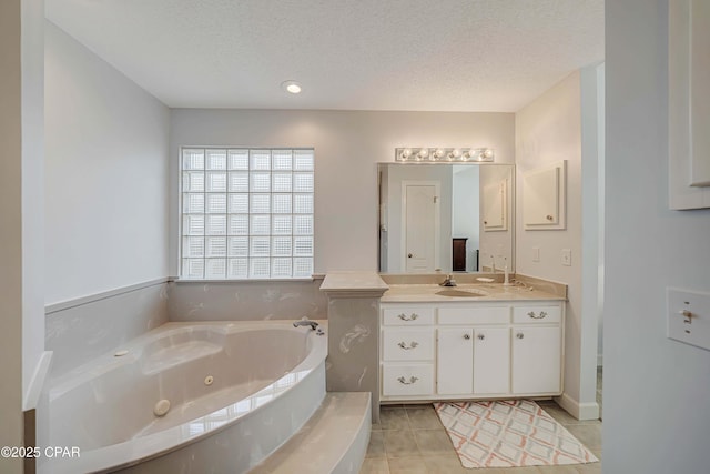 bathroom featuring vanity, a tub to relax in, tile patterned flooring, and a textured ceiling