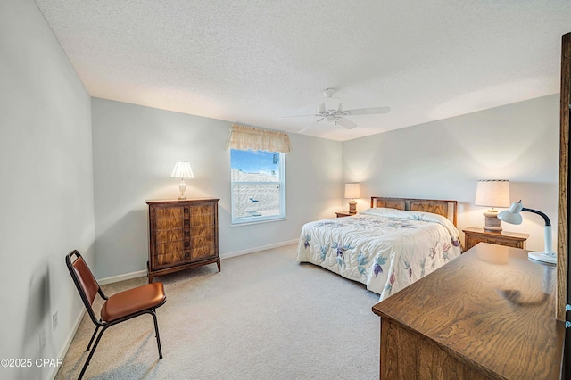 bedroom featuring light colored carpet, a textured ceiling, and ceiling fan