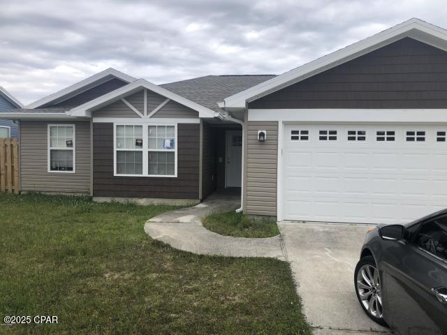 view of front of house with a garage and a front lawn