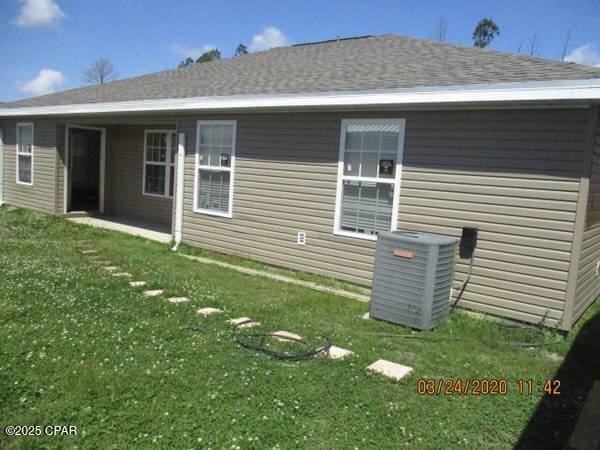 view of home's exterior with a yard and central AC