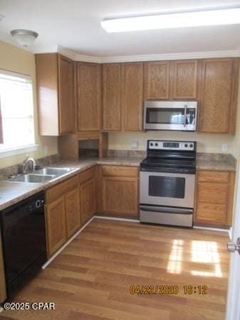 kitchen with sink, stainless steel appliances, and light hardwood / wood-style flooring